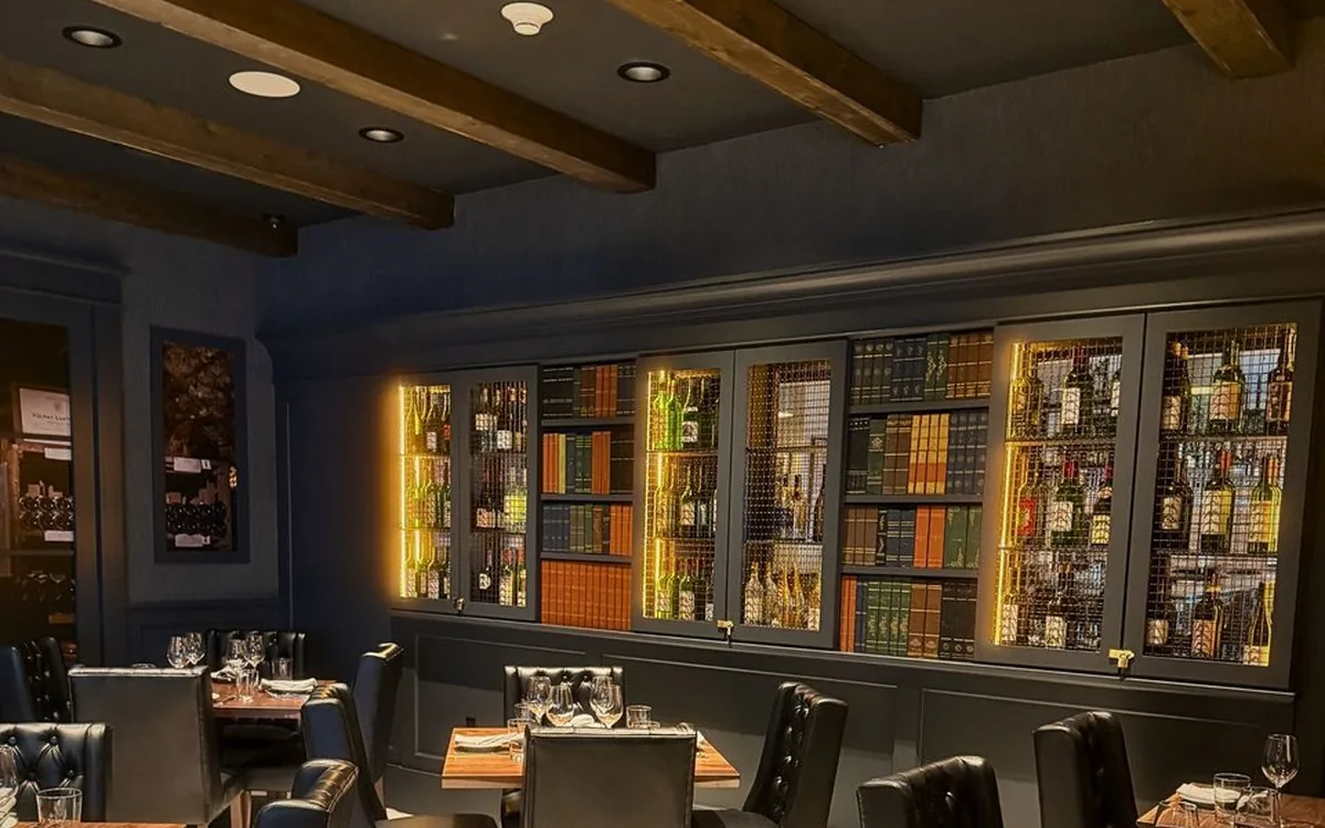 The Enology dining room with its backlit library wall of wine bottles