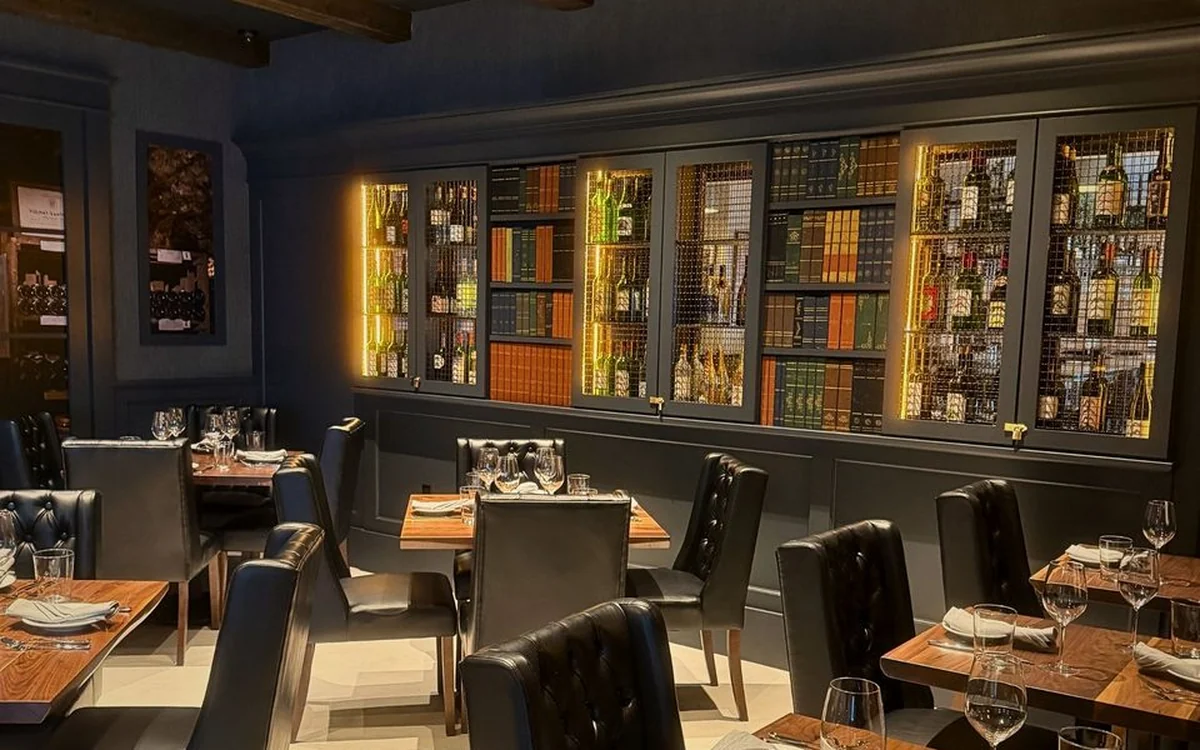 The Enology dining room with its backlit library wall of wine bottles