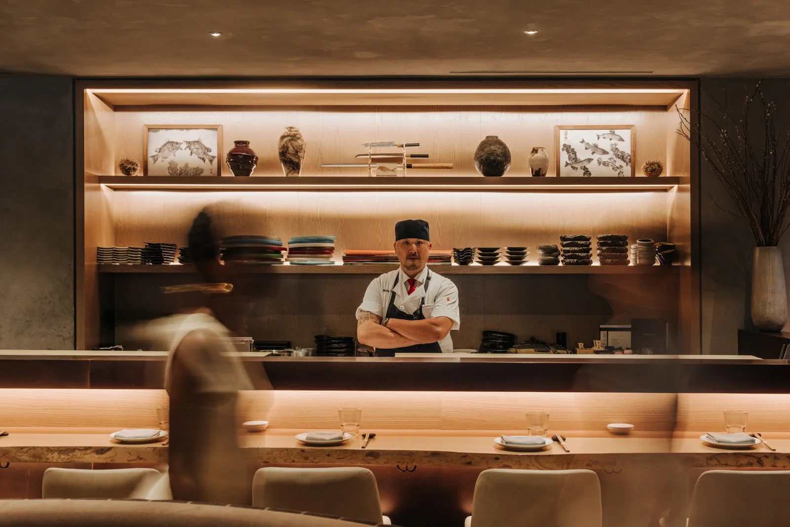 Chef Bryan Yee, arms crossed, behind the sushi counter at Okaru in Roslyn